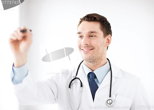 Image of young doctor working with something imaginary