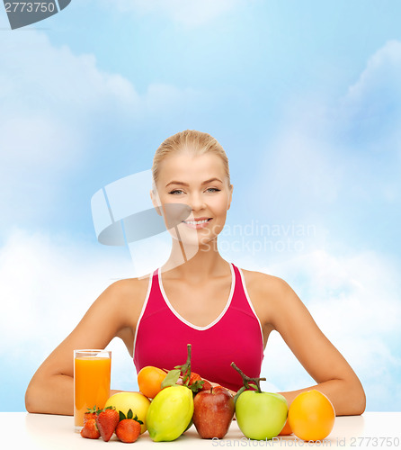 Image of smiling woman with organic food or fruits on table