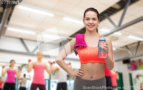 Image of sporty woman with towel and water bottle