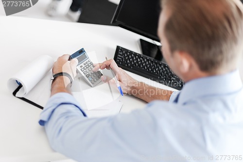 Image of businessman with notebook and calculator