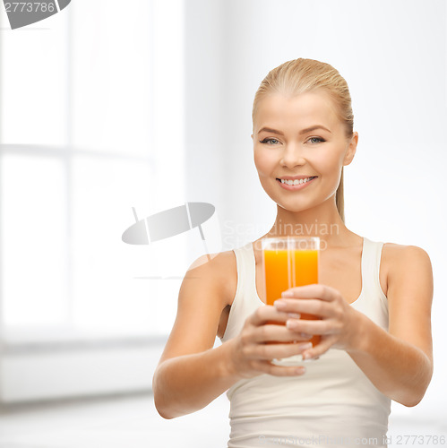 Image of smiling woman holding glass of orange juice