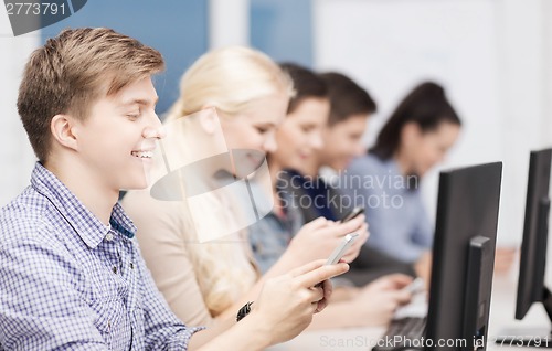 Image of students with computer monitor and smartphones