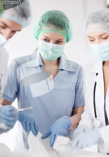 Image of young group of doctors doing operation