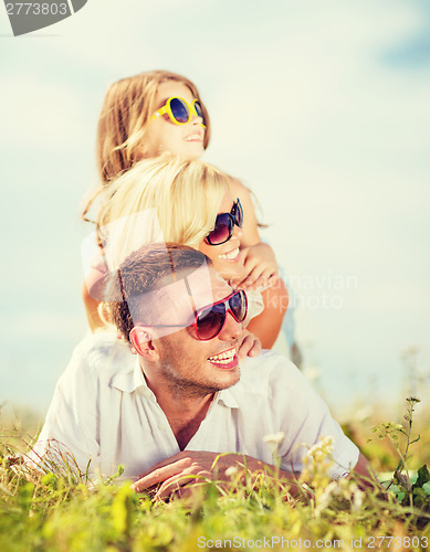 Image of happy family with blue sky and green grass