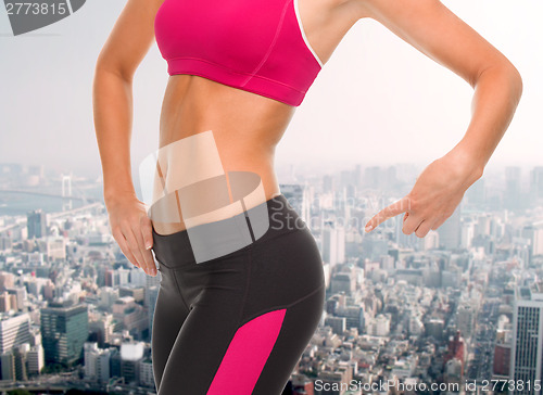 Image of close up of sporty woman pointing at her buttocks