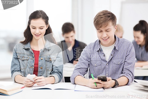 Image of students looking into smartphone at school