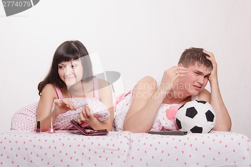 Image of Husband not upset by a goal scored, skeptical wife smiling