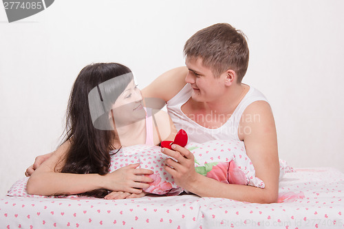 Image of Loving guy gives the girl an engagement ring
