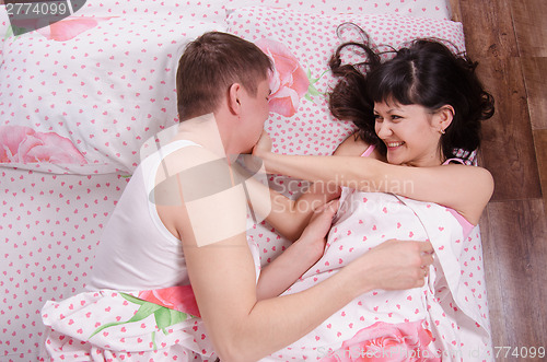 Image of Young couple pretended to fight morning in bed