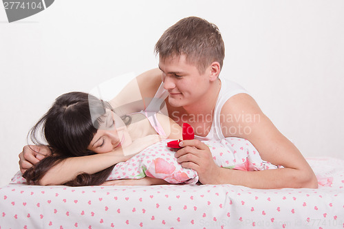 Image of Man gives sleeping girl ring