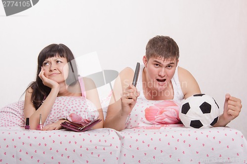 Image of Husband picked the TV remote and watch soccer