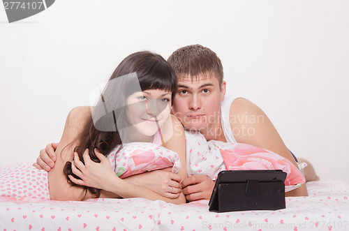 Image of Young couple in bed with tablet