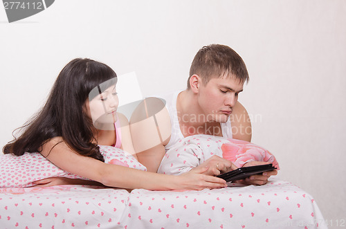 Image of Man and woman share a tablet computer