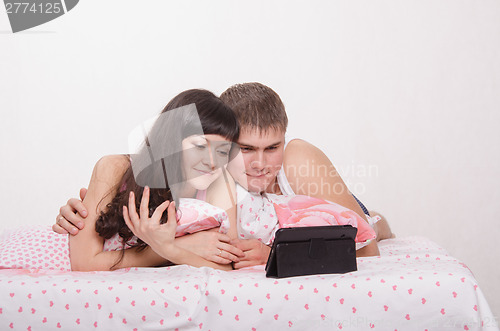 Image of Young couple having fun watching a movie in plate