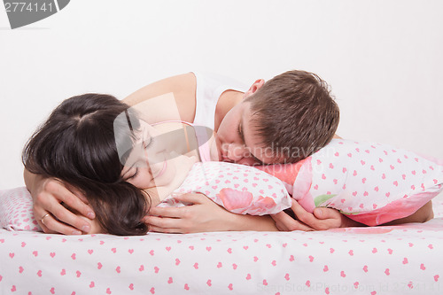 Image of Two young men sleep in bed and see pleasant dreams