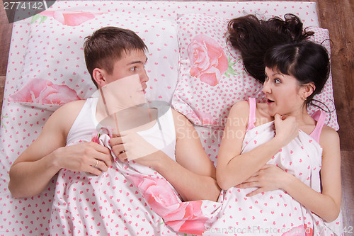 Image of Unfamiliar man and woman wake up in bed