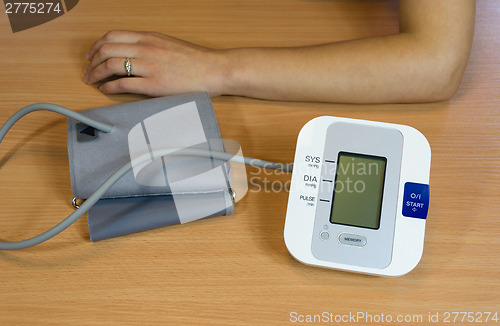 Image of hands and digital blood pressure measurement  