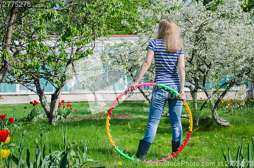 Image of woman hold colorful hula hoop nature background  