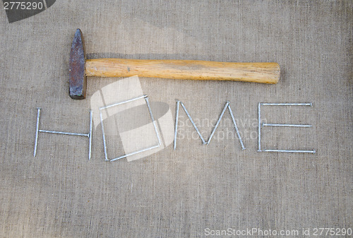 Image of hammer and inscription of nails on linen texture   