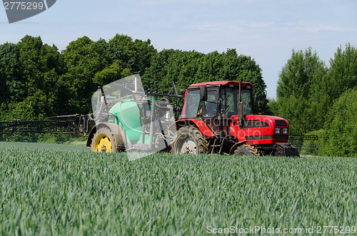 Image of farm machinery tractor long sprayer work in field 