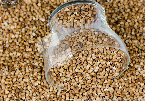 Image of cup of raw eco buckwheat pile background 