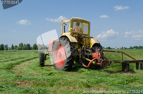 Image of tractor cut grass makes bend in meadow  