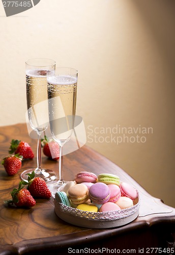 Image of Two glasses of sparkling wine or champagne with small colorful macaroons