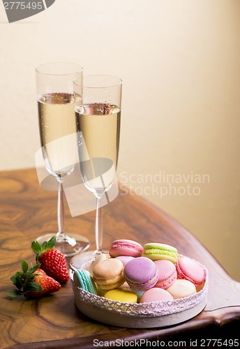Image of Two glasses of sparkling wine or champagne with small colorful macaroons