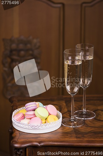 Image of Two glasses of sparkling wine or champagne with small colorful macaroons