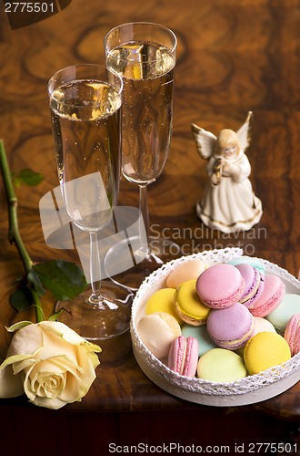 Image of Two glasses of sparkling wine or champagne with small colorful macaroons