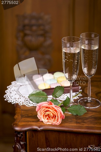 Image of Two glasses of sparkling wine or champagne with small colorful macaroons