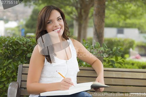 Image of Young Adult Female Student on Bench Outdoors