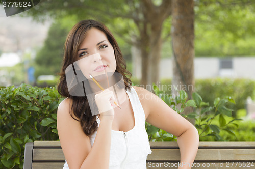Image of Young Adult Female Student on Bench Outdoors