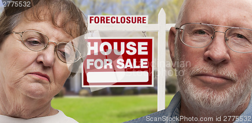 Image of Depressed Senior Couple in Front of Foreclosure Sign and House