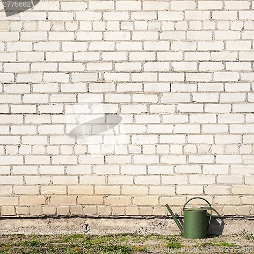 Image of watering can near the wall