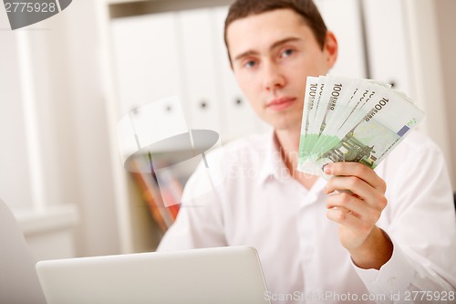 Image of man with Euro in office