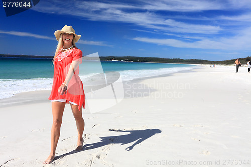 Image of Happy woman walking along beautiful beach