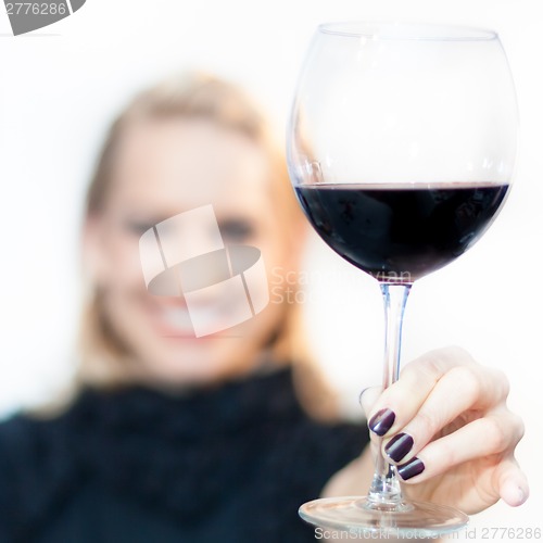 Image of Toasting with a glass of red wine.