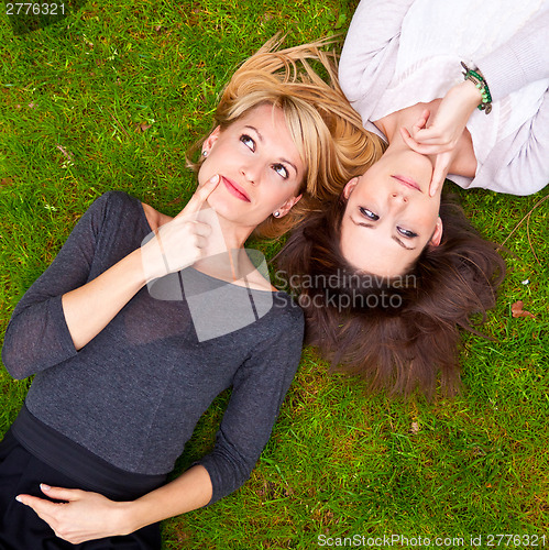 Image of Two girls brainstorming in the meadow.