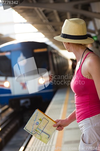 Image of Young woman on platform of railway station.