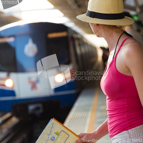 Image of Young woman on platform of railway station.