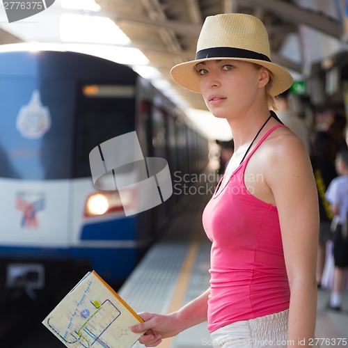 Image of Young woman on platform of railway station.