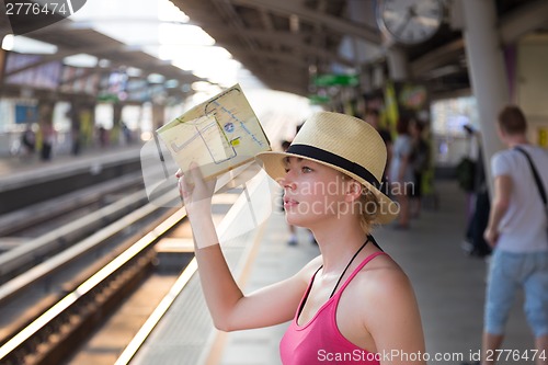 Image of Young woman on platform of railway station.