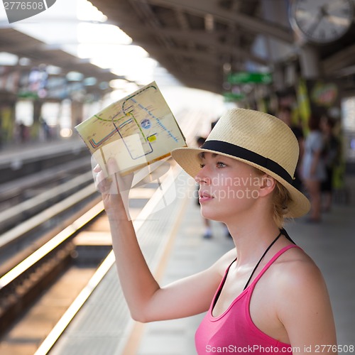 Image of Young woman on platform of railway station.