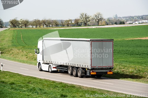 Image of White truck moving on a main road