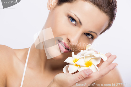 Image of Beautiful woman holding flowers