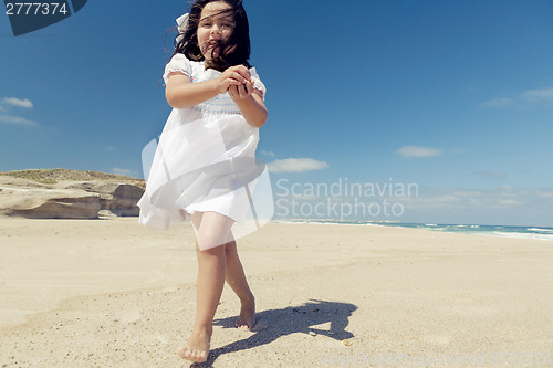Image of Girl on the beach holding stones