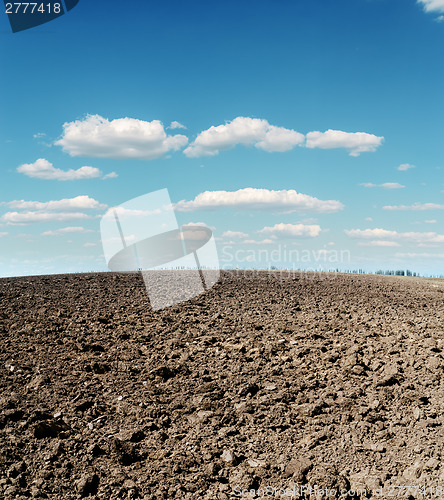 Image of plowed field and cloudy sky