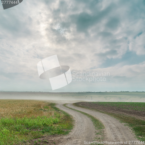 Image of dirty road with dust and dramatic sky over it