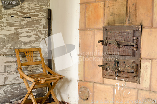 Image of old rustic furnace doors and wooden rest chair 